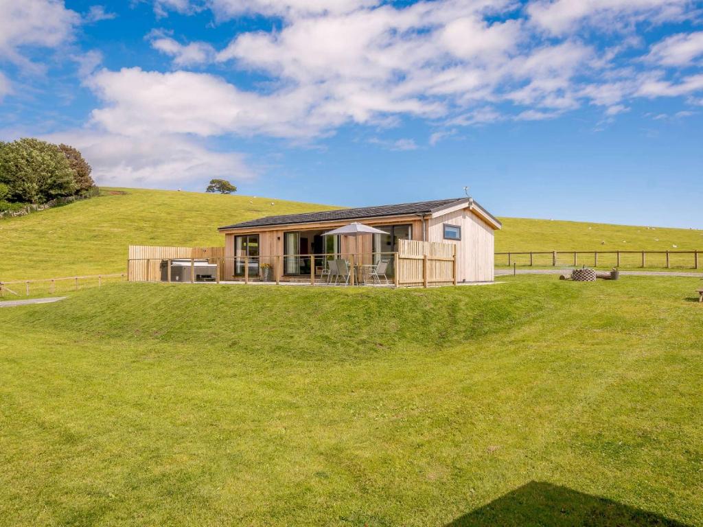 a small house on top of a grassy hill at 2 Bed in Castle Douglas 86449 in Auchencairn