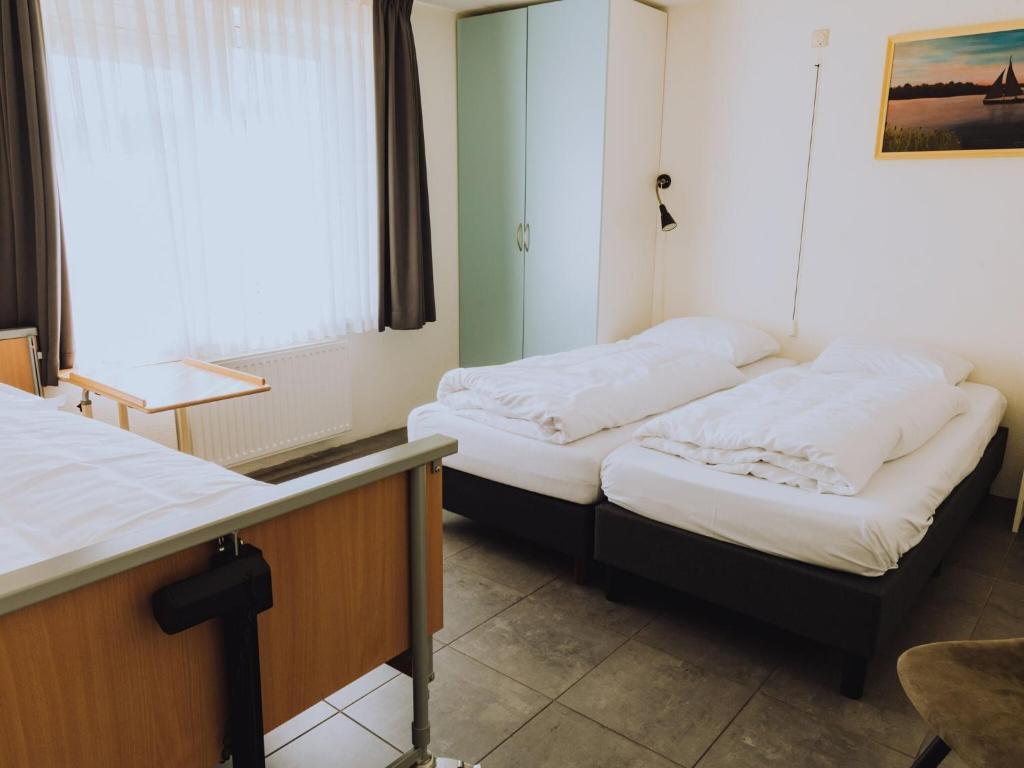 UitgeestにあるHouse by Uitgeestermeer with Gardenの窓のある部屋にツインベッドが2台
