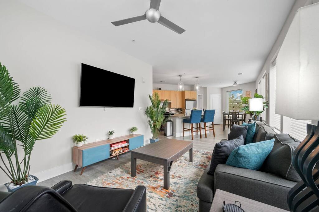 a living room with a couch and a tv on a wall at Lux 3BR Near Truist Park & Mall in Atlanta