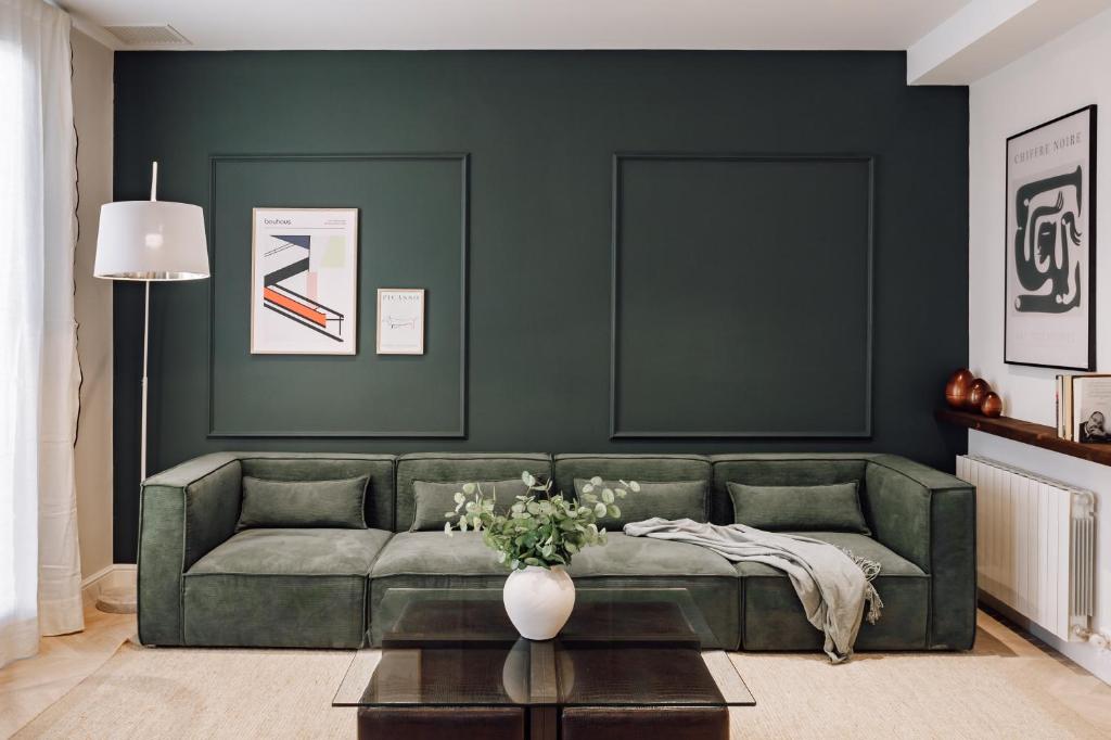 ein Wohnzimmer mit einem grünen Sofa und einem Tisch in der Unterkunft Lunalux Apartment in Barcelona