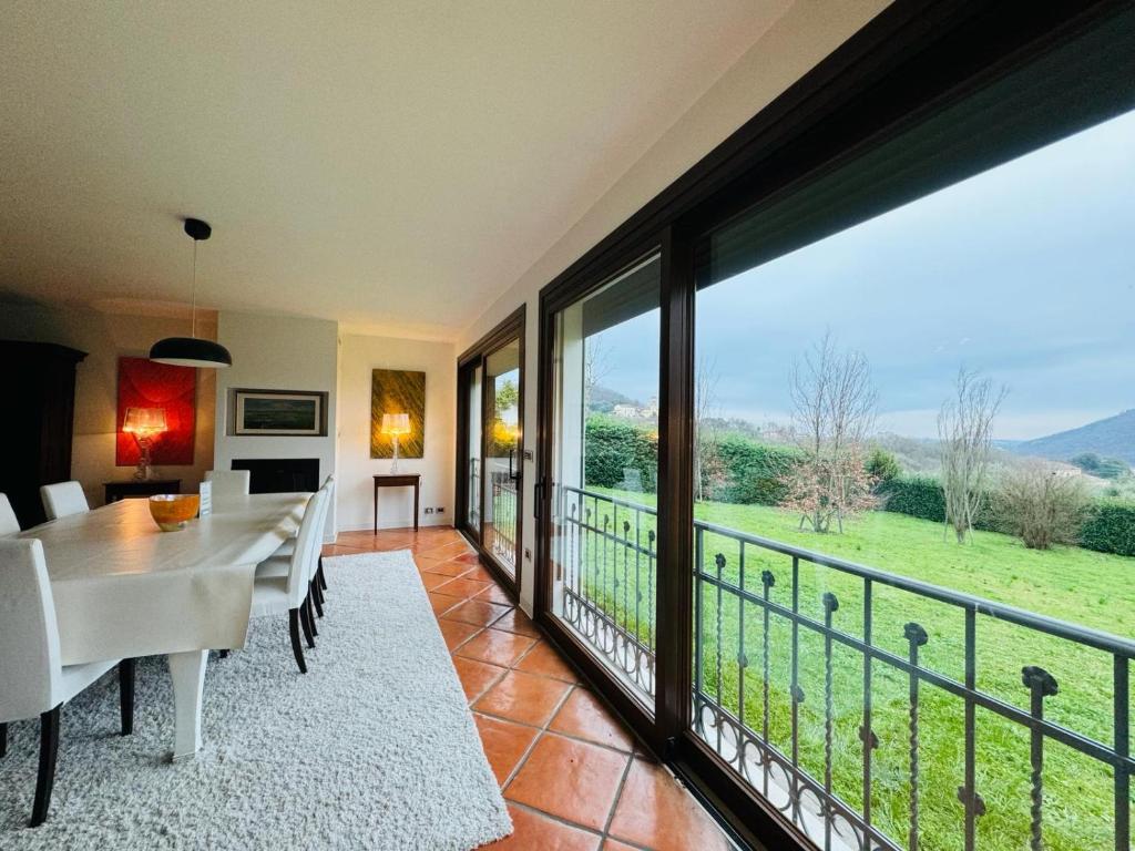 uma sala de jantar com uma mesa e uma grande janela em Villa Tramonte em Monte Ortone