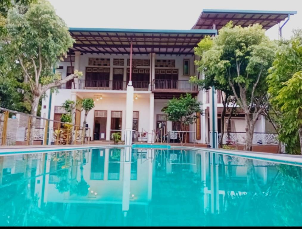 an image of a swimming pool in front of a house at Jayaa Villas Bolgoda in Panadura