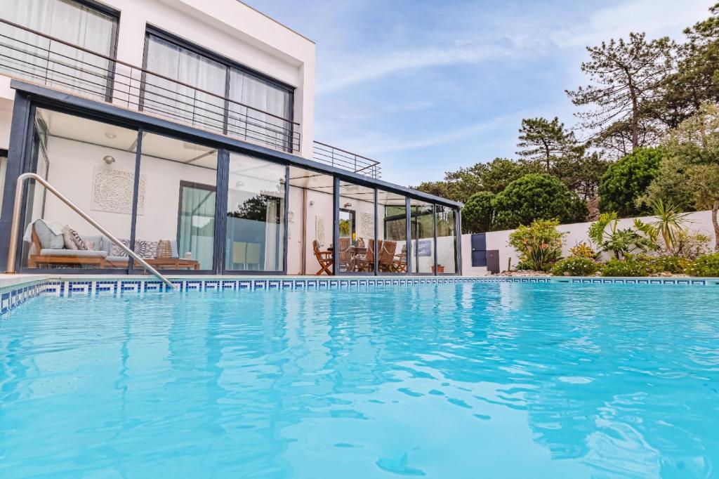 a large swimming pool in front of a house at Maresia Villa Mar in Nazaré