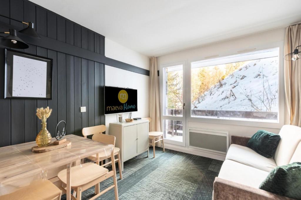 een woonkamer met een eettafel en een tv bij Résidence Plagne Lauze - maeva Home - Appartement 2 Pièces 4 Personnes - Séle 64 in Mâcot La Plagne