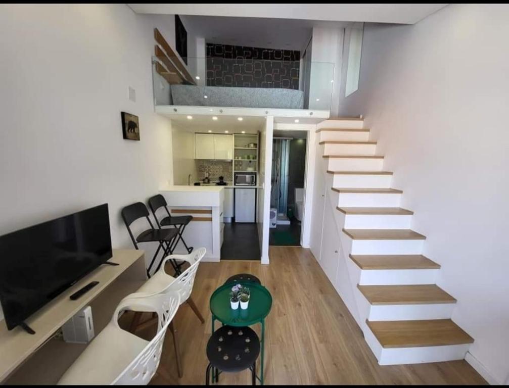 una escalera que conduce a una sala de estar y una cocina en Estúdio mobilado com cozinha na Covilhã, en Covilhã