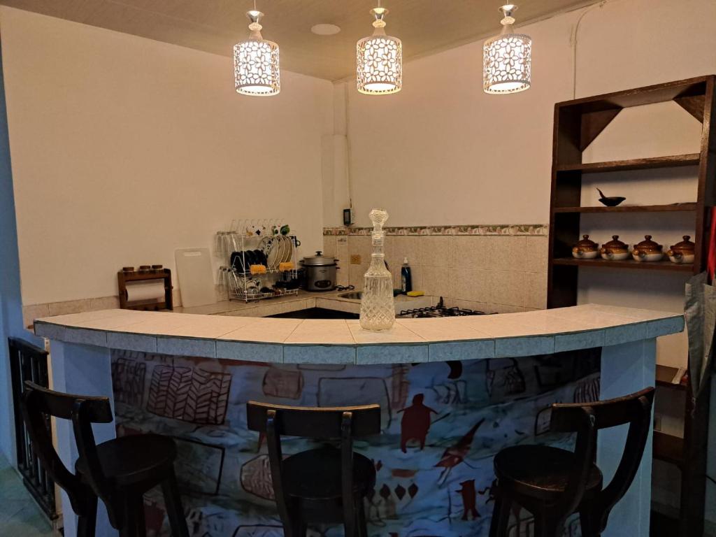 kuchnia z wyspą z krzesłami wokół niej w obiekcie Casa La Ceiba w San José Del Guaviare