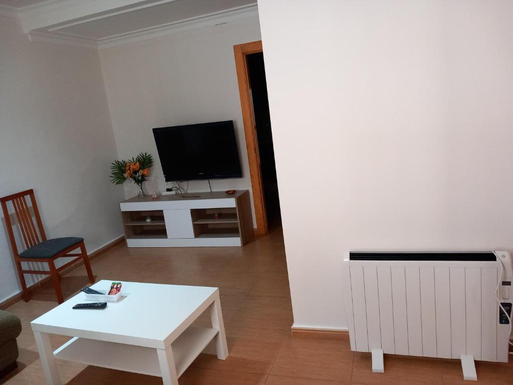 a living room with a white table and a tv at Apartamento los rosales in Letur