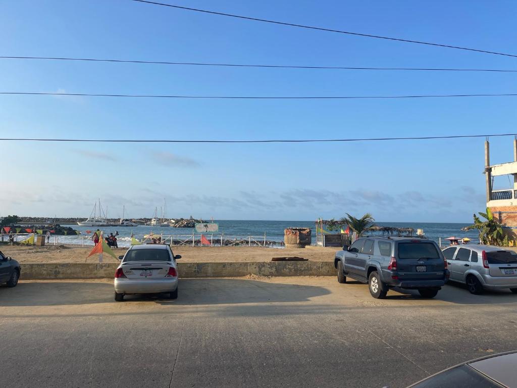 un grupo de coches estacionados en un estacionamiento cerca de la playa en Hotel brisas del mar 2022, en Catia La Mar