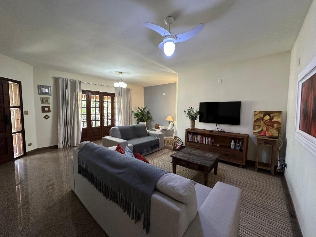 un soggiorno con divano e TV di Recanto Amana · Casa inteira · Centro em São João da Boa Vista a São João da Boa Vista