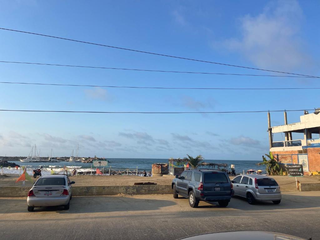Catia La Mar的住宿－Hotel brisas del mar 2022，三辆车停在海滩附近的停车场