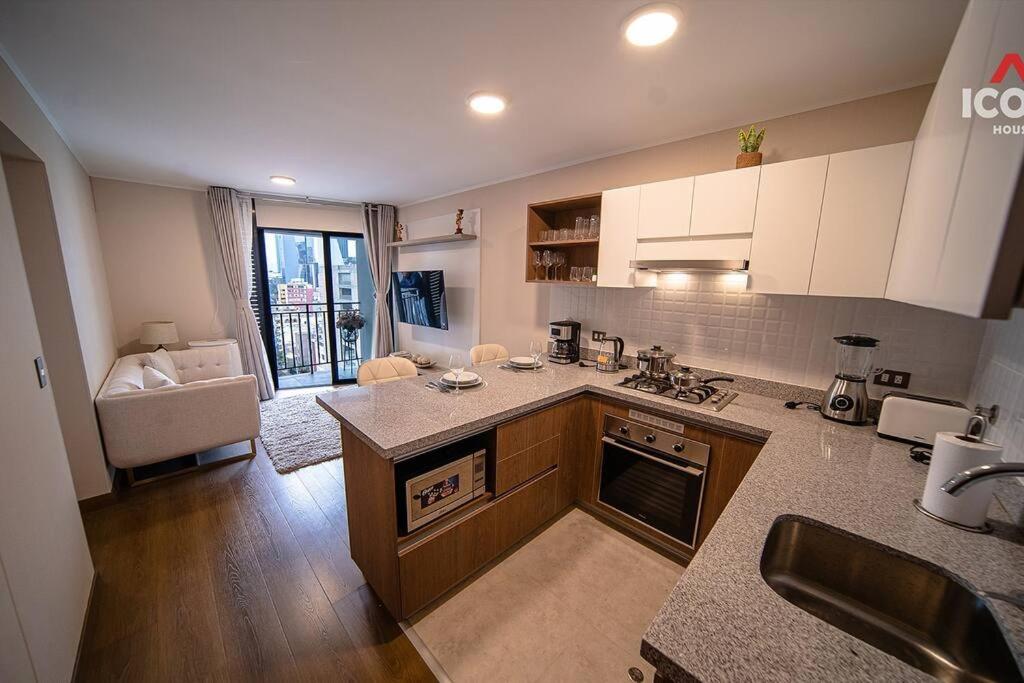 a kitchen with a sink and a stove top oven at Elegant 1BR in San Isidro / Pool in Lima