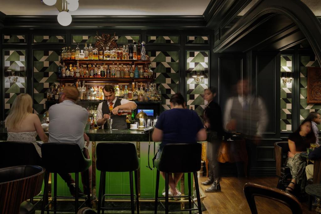 un grupo de personas sentadas en un bar en La Colombe d'Or Hotel en Houston