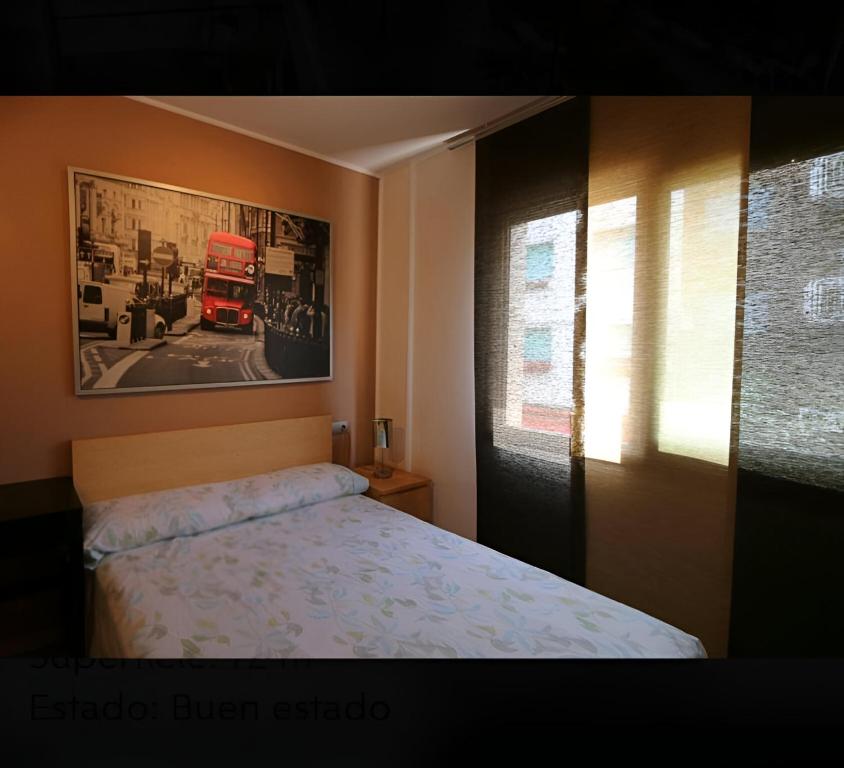 a bedroom with a bed and a window with a truck at Apartament Calella in Calella