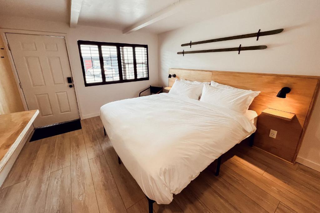 a bedroom with a large white bed and a window at The Timberline in Leadville