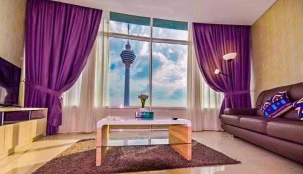 a living room with purple curtains and a large window at Vortex suites KLCC By Moonlight in Kuala Lumpur