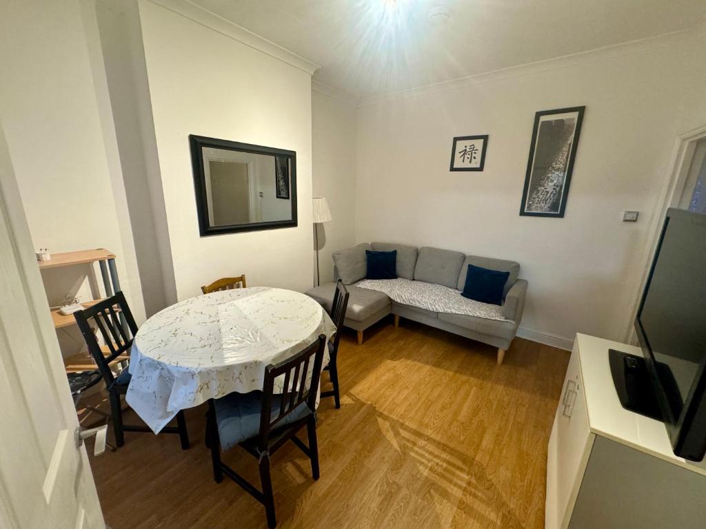 sala de estar con mesa y sofá en 4 Bedroom House in Turnpike Lane/Wood Green en Londres