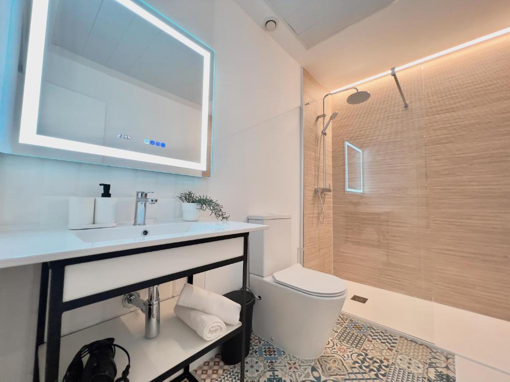 ein Bad mit einem Waschbecken, einem WC und einer Dusche in der Unterkunft Sorolla Urban Suites in Valencia