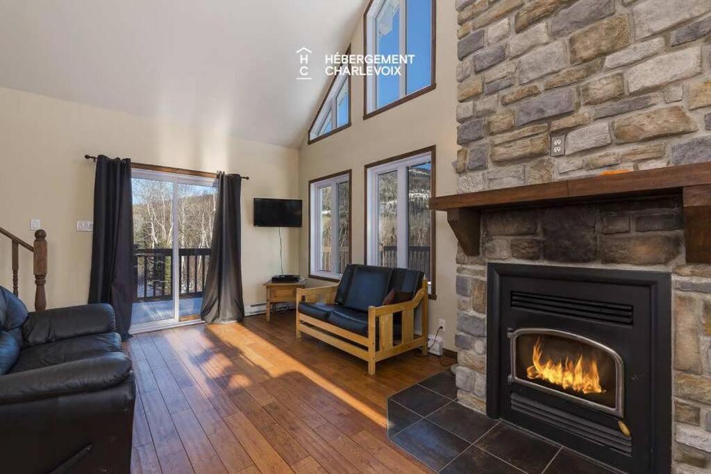 a living room with a fireplace and a couch at Au chalereux chalet Petite-rivière-saint-françois in Petite-Rivière-Saint-François