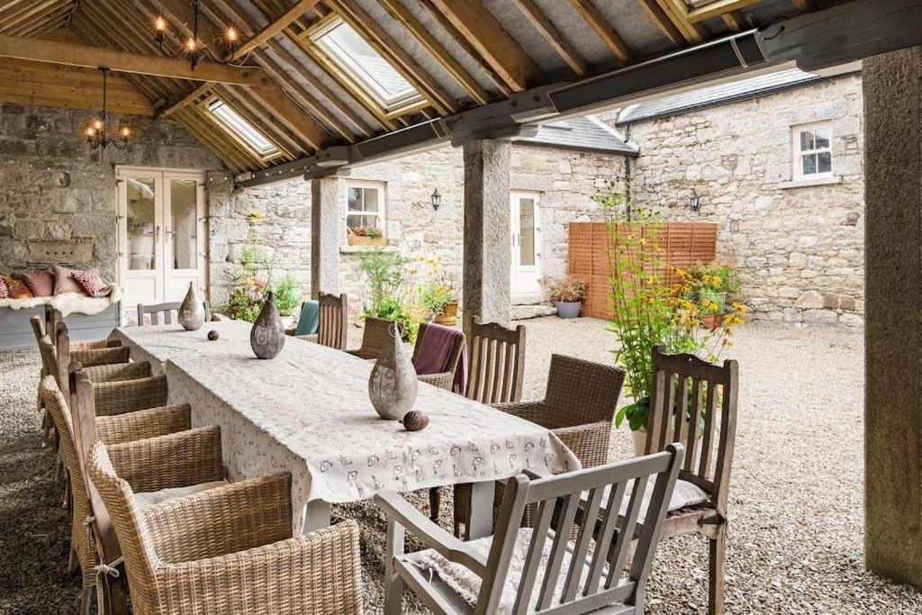 a long table with chairs and vases on it at Stunning Granite Barn Conversion in Tullow