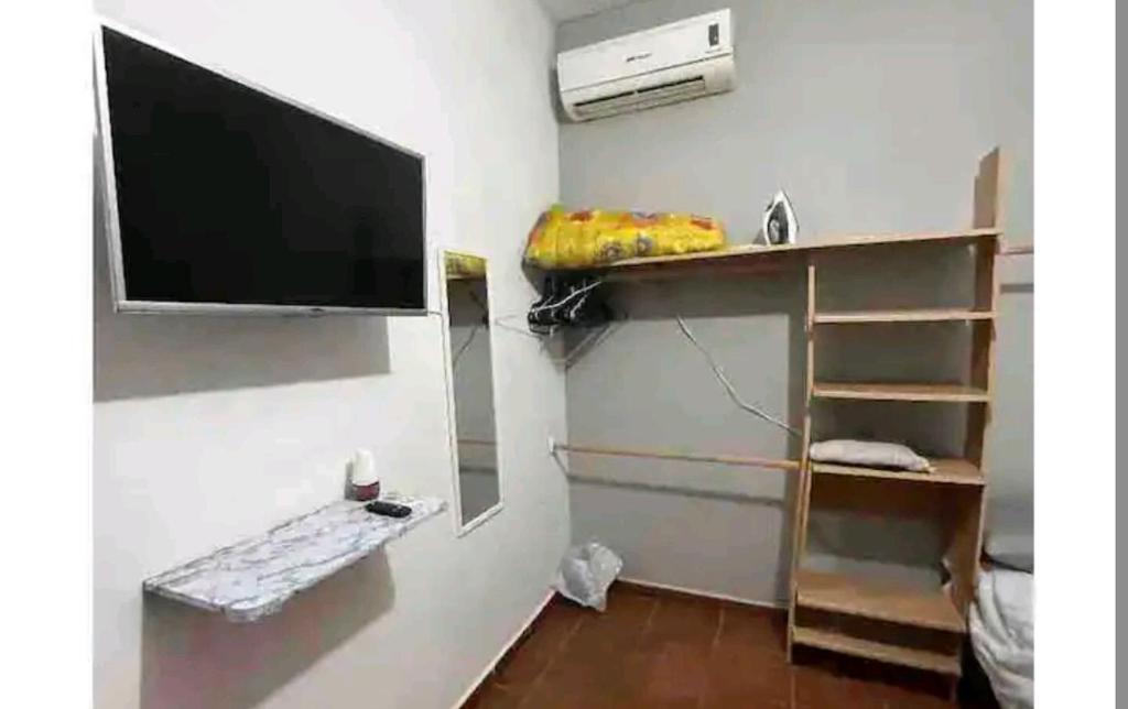 uma sala de estar com uma televisão de ecrã plano na parede em Habitación equipada em Bacurimi