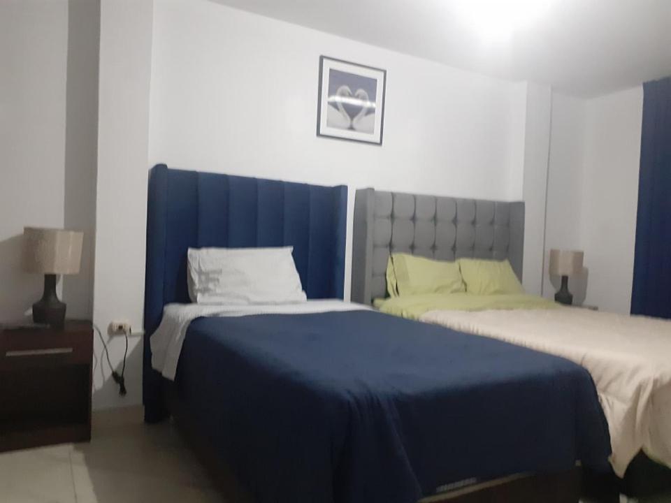 1 Schlafzimmer mit 2 Betten mit blauer und weißer Bettwäsche in der Unterkunft Casa-Posada in Cajamarca