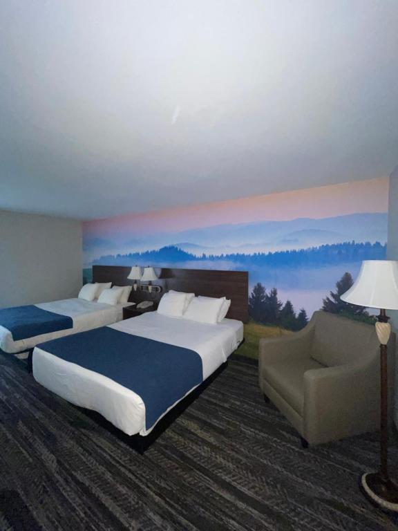 une chambre d'hôtel avec deux lits et un canapé dans l'établissement Clarion Pointe, à Dillard