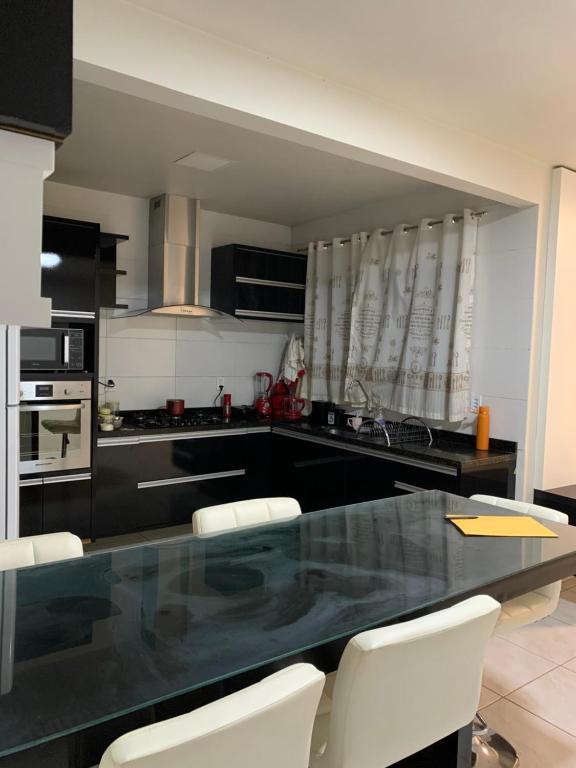 a kitchen with a table and some white chairs at Casa espaçosa e aconchegante in Luís Eduardo Magalhães