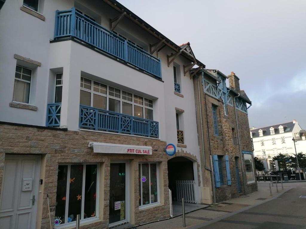 een wit gebouw met blauwe balkons in een straat bij LA MAISON BLEUE in Quiberon