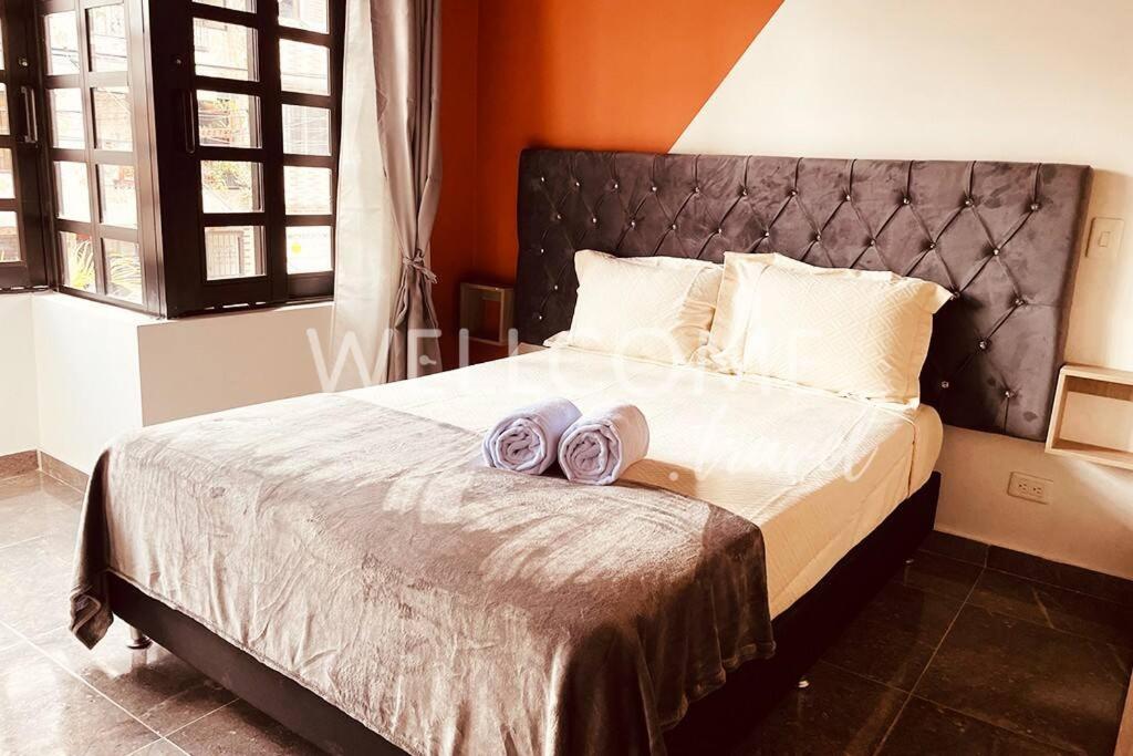 um quarto com uma cama grande com duas toalhas em Loft Central cerca de El Poblado em Itagüí