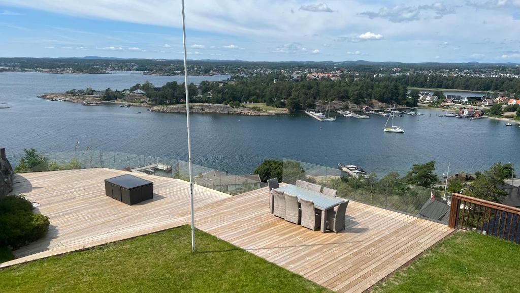 um deque de madeira com bancos e vista para um lago em Moderne nydelig villa med Panorama Utsikt em Sandefjord