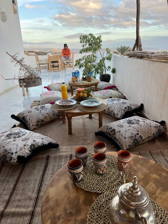 un tavolo e cuscini su un balcone con tavolo e tavolo di rise surf and yoga morocco ad Agadir