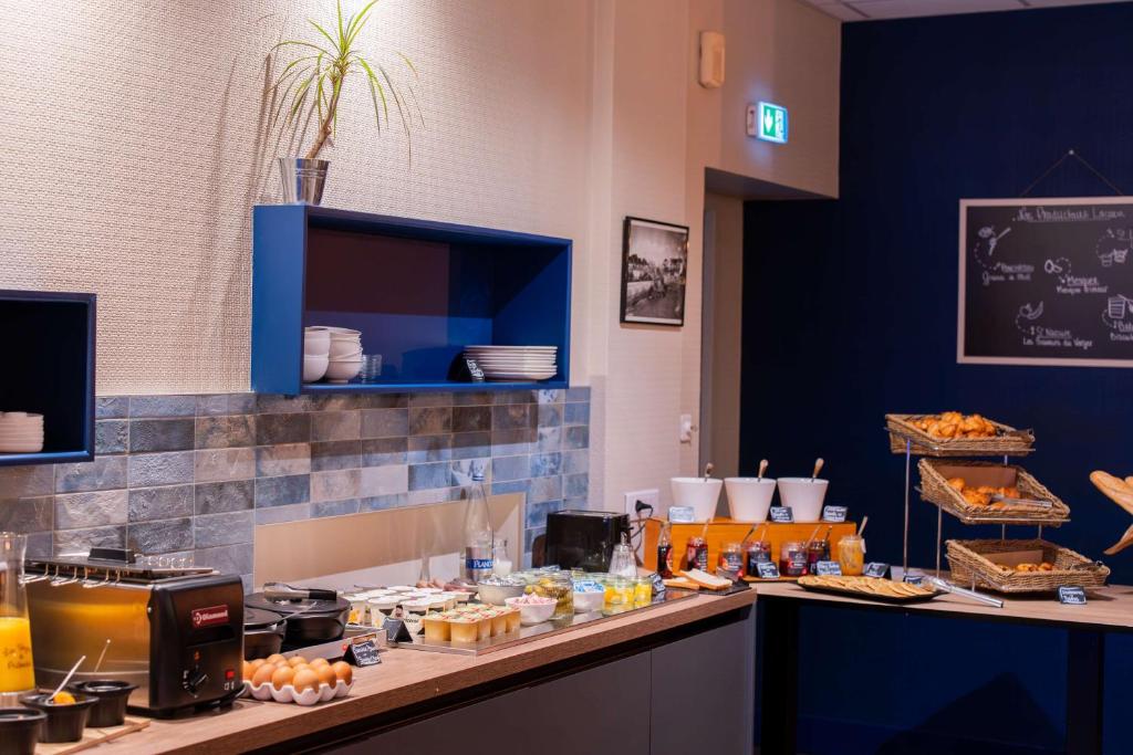 a kitchen with a counter with food on it at Best Western Hotel De La Plage Saint Marc sur Mer in Saint-Nazaire