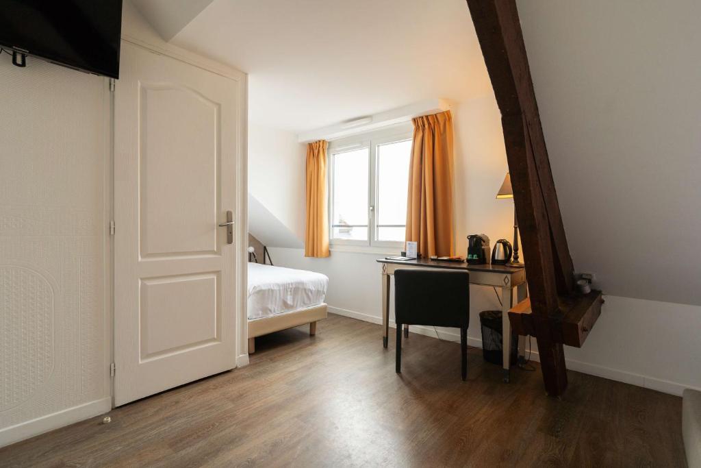 a bedroom with a bed and a desk and a window at Best Western Hotel De La Plage Saint Marc sur Mer in Saint-Nazaire