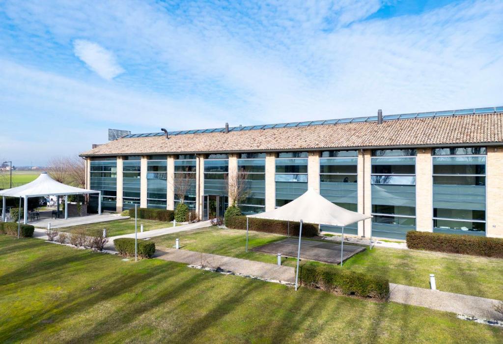 a large building with a lawn in front of it at Best Western Hotel Green City in Parma