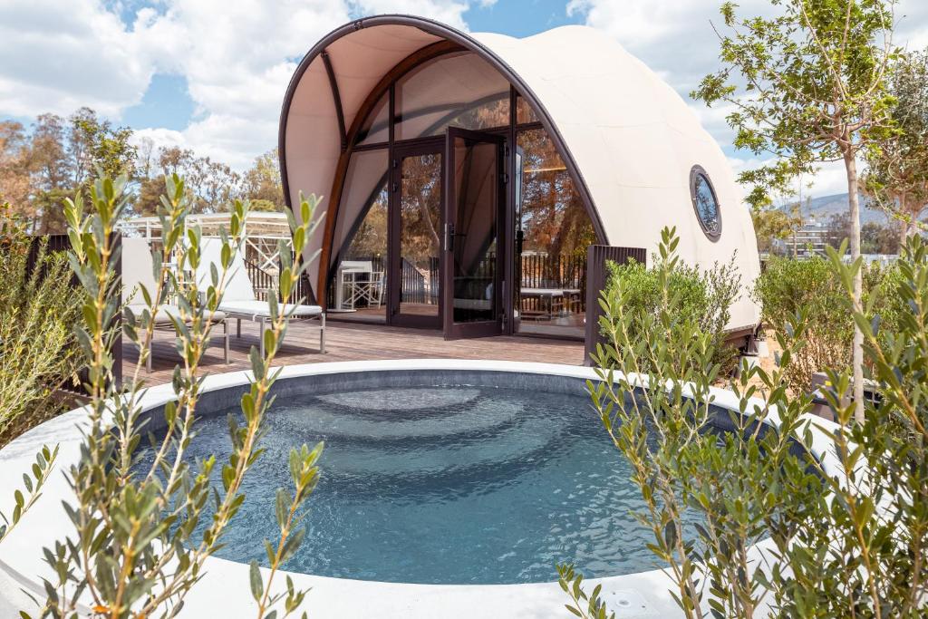 una piscina circolare di fronte a una cupola di 91 Athens Riviera, The Resort ad Atene