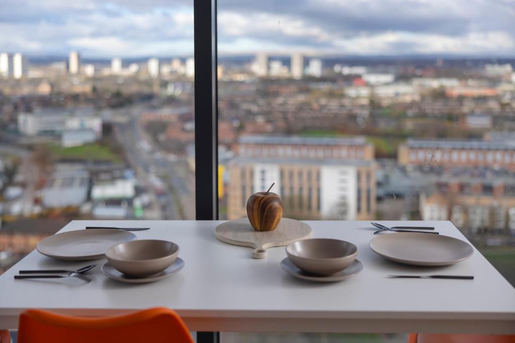 uma mesa com três tigelas e um caracol sobre ela em Quayside Penthouse 2 BedRoom Ensuite near Media City & Manchester United em Manchester