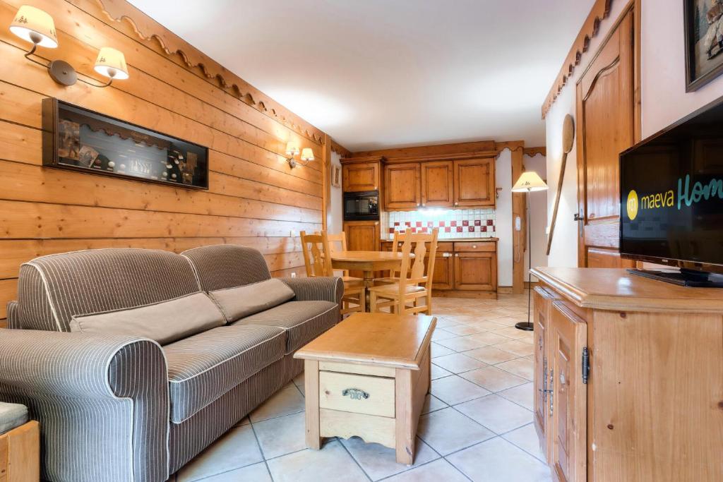 a living room with a couch and a tv at Résidence L'Ecrin des Neiges - maeva Home - Appartement 2 pièces 4 personnes - Sélection MAE-7984 in Tignes