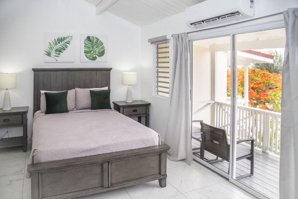 a bedroom with a bed and a balcony at 101G Jolly Harbour, Garden View in Jolly Harbour