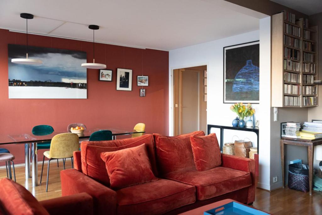 a living room with a red couch and a table at Spacious apartment near Champ-de-Mars in Paris