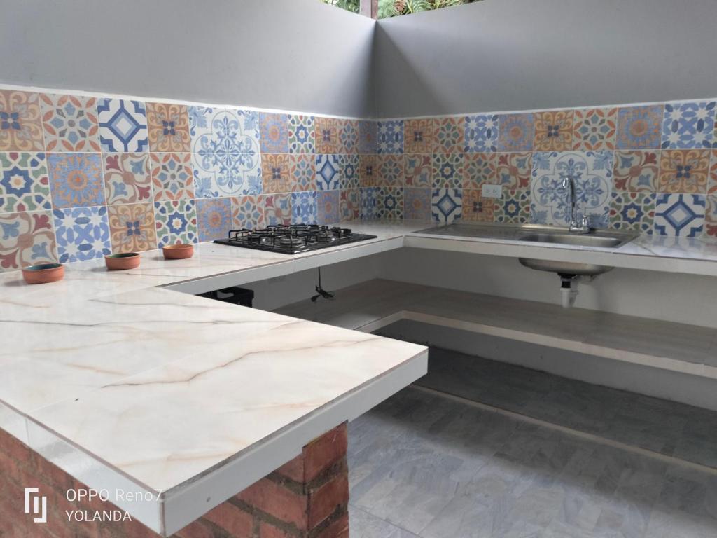 a kitchen with a counter and a sink and tiles at Irakara hotel campestre in La Palma