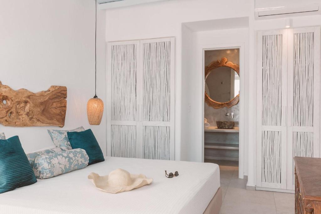 een witte woonkamer met een witte bank en een spiegel bij Villa Konstantin in Mykonos-stad