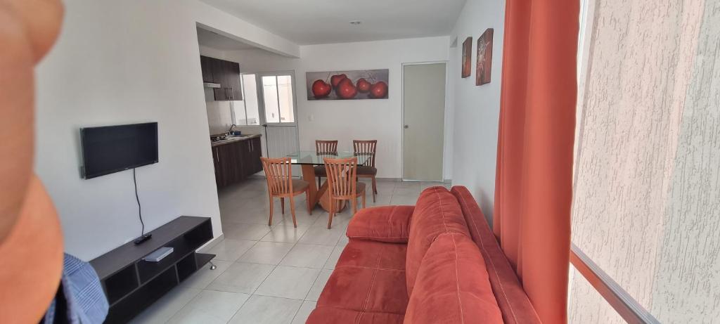 uma sala de estar com um sofá e uma sala de jantar em Depa cerca Antea Villas A em Querétaro
