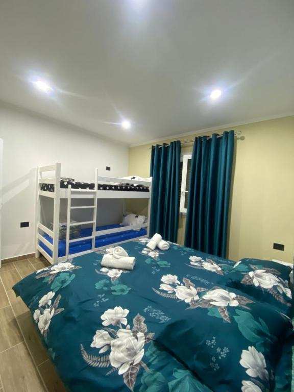 een slaapkamer met een blauw dekbed en een stapelbed bij Hodo guest house in Përmet
