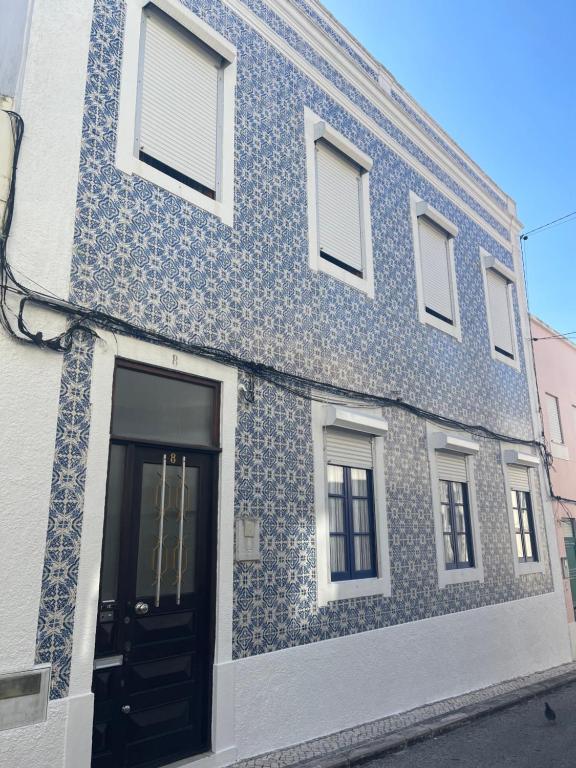un bâtiment bleu et blanc avec une porte noire dans l'établissement Patio da Foz - Appartement très accueillant centre-ville, à Figueira da Foz