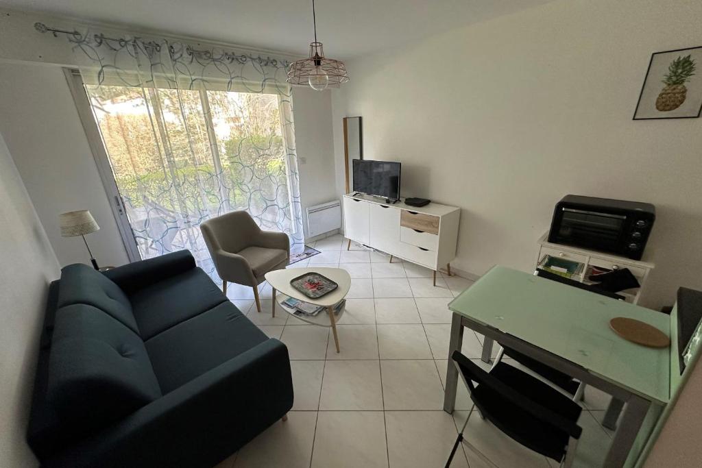un salon avec un canapé bleu et une télévision dans l'établissement Cosy love cocoon close to the sea, à La Baule