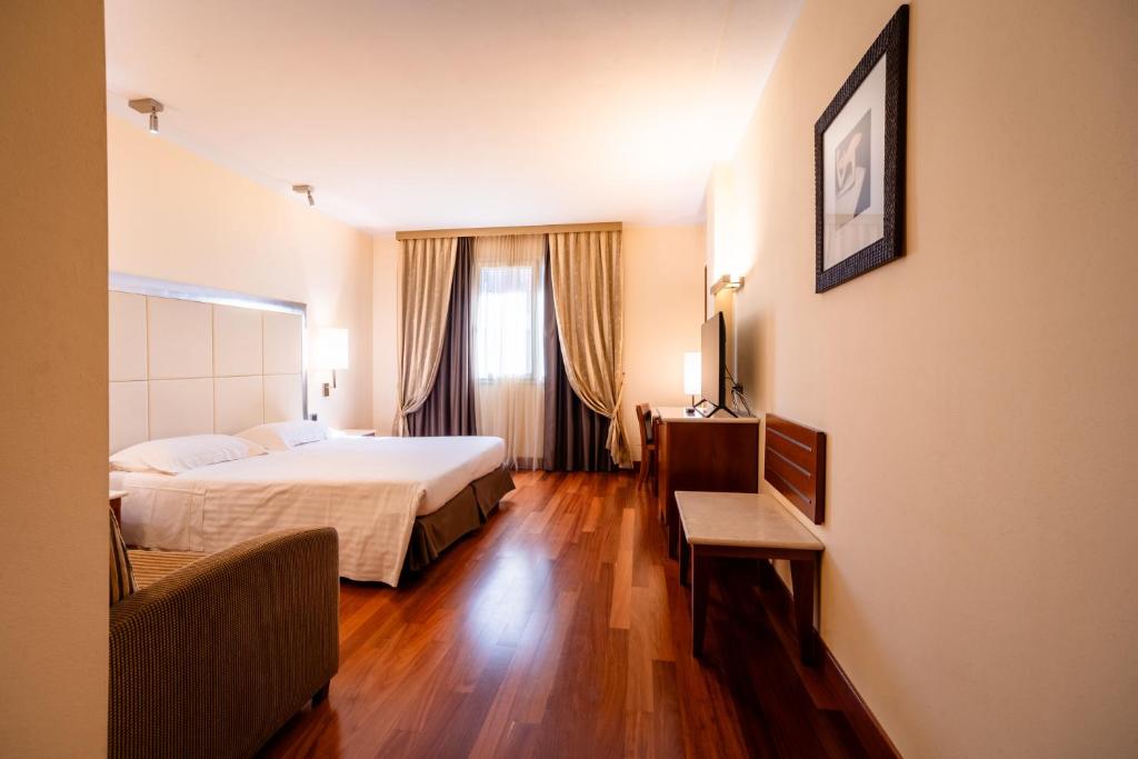 a hotel room with a bed and a window at Hotel Airone - Ombrellone incluso al bagno Dolce Vita a Marina dal 15 giugno al 15 settembre in Grosseto