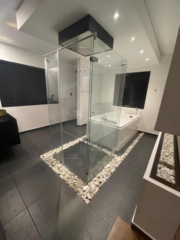 a glass shower in a room with a rug at Casa amarilla suite in Filandia