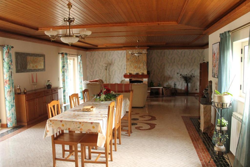 a dining room with a table and chairs and a kitchen at Casa das Laranjeiras in Alqueidão da Serra