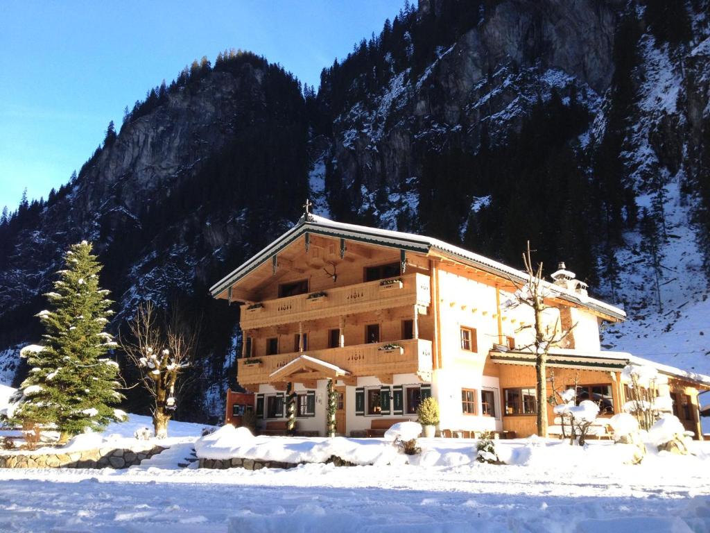 um grande edifício na neve em frente a uma montanha em Alpenhaus Lacknerbrunn em Mayrhofen
