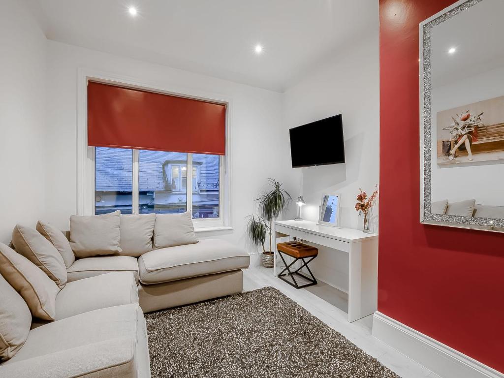 sala de estar con sofá blanco y pared roja en Dragon Pad - Uk46422 en Royal Tunbridge Wells